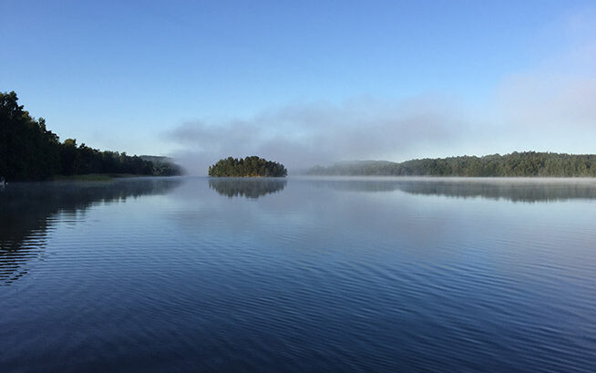 En sjö, borta i horisonten syns träd.